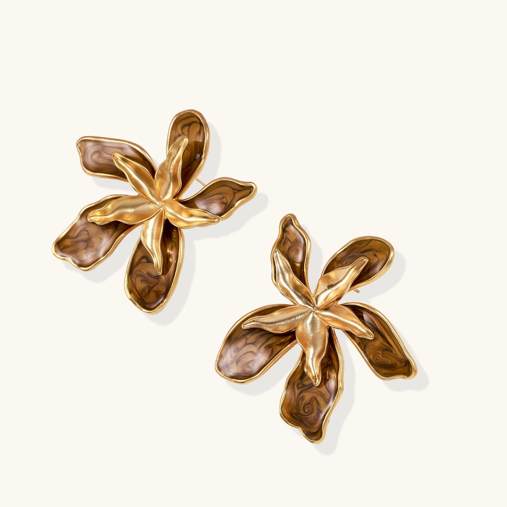 Large gold-plated flower earrings with brown enamel marbled petals on beige background, showing intricate floral design.