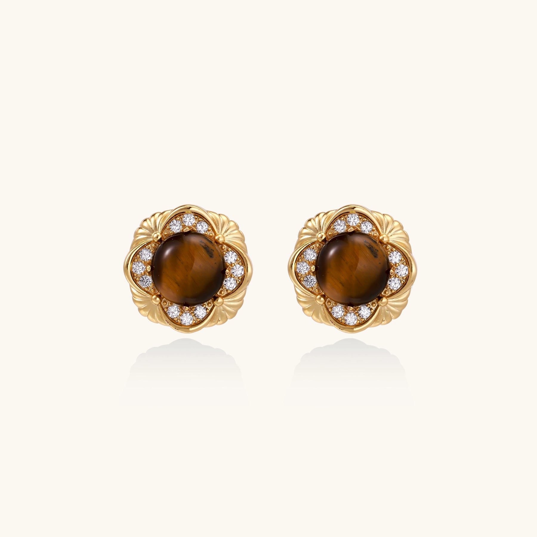 Ornate gold-plated brass stud earrings featuring round tiger's eye stones surrounded by sparkling zirconia in floral design