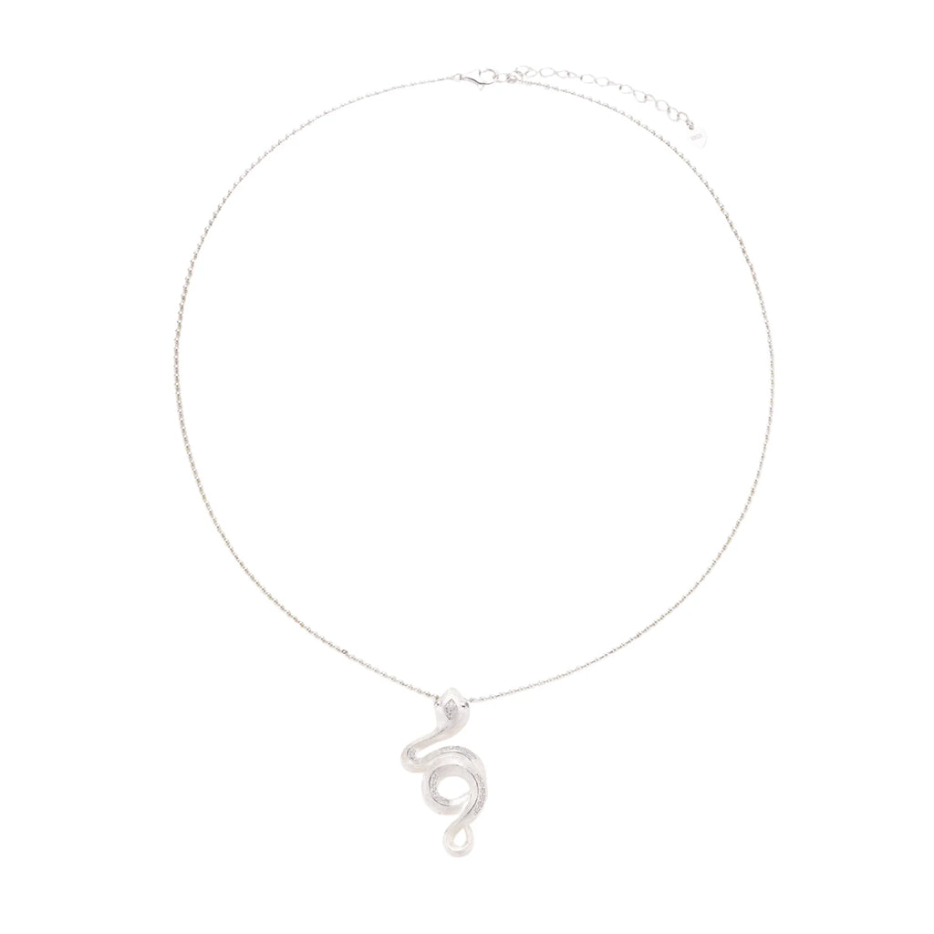 Abstract S-curve sterling silver pendant with zirconia accents on delicate chain against white background