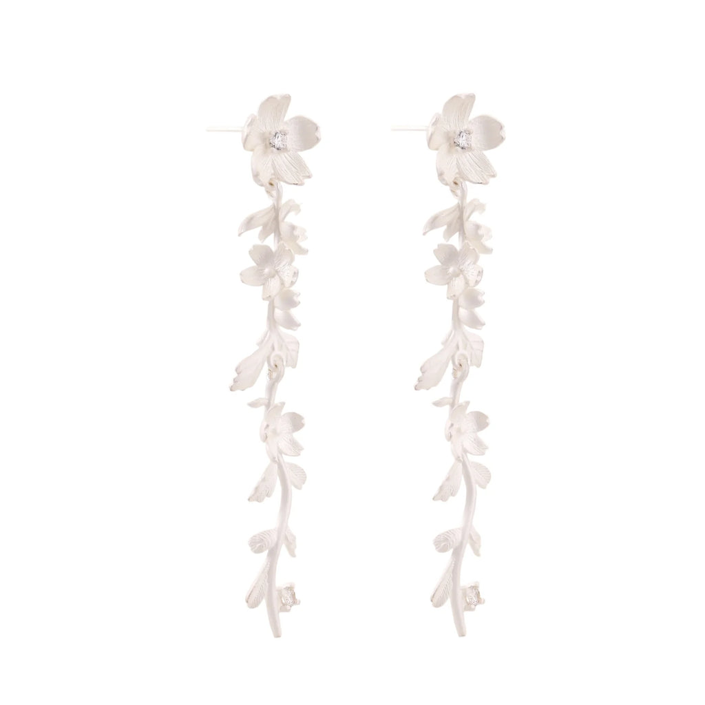 Long sterling silver drop earrings with delicate floral vine design and crystal accents on white background
