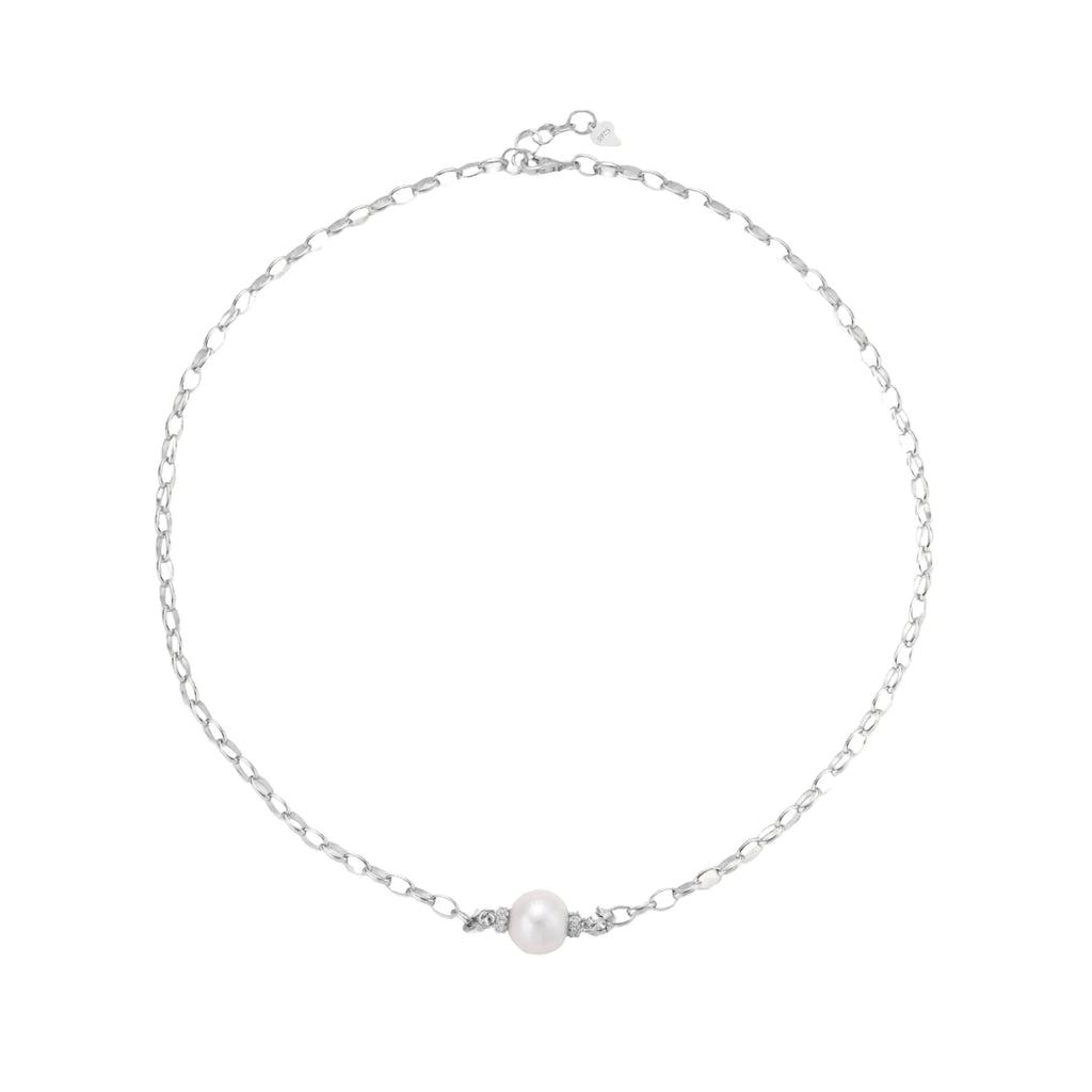 Dainty rhodium-plated silver chain necklace with centered 10mm freshwater pearl and crystal accents on cream background